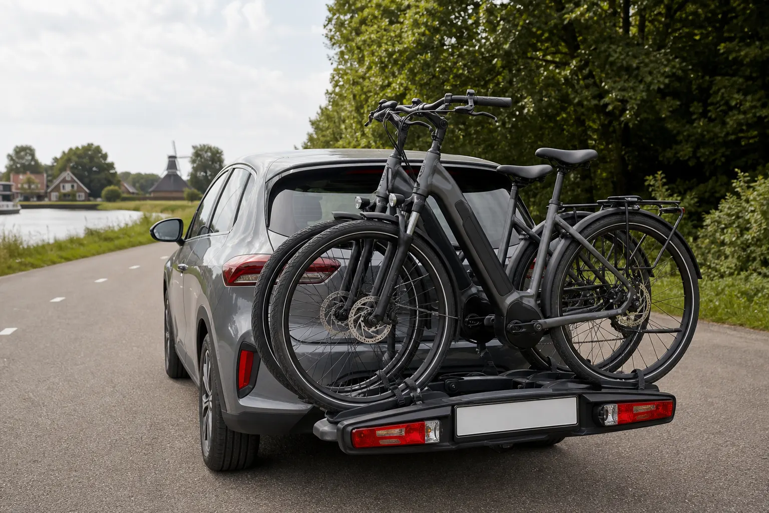 Twee e-bikes op een trekhaakdrager achter een compacte auto
